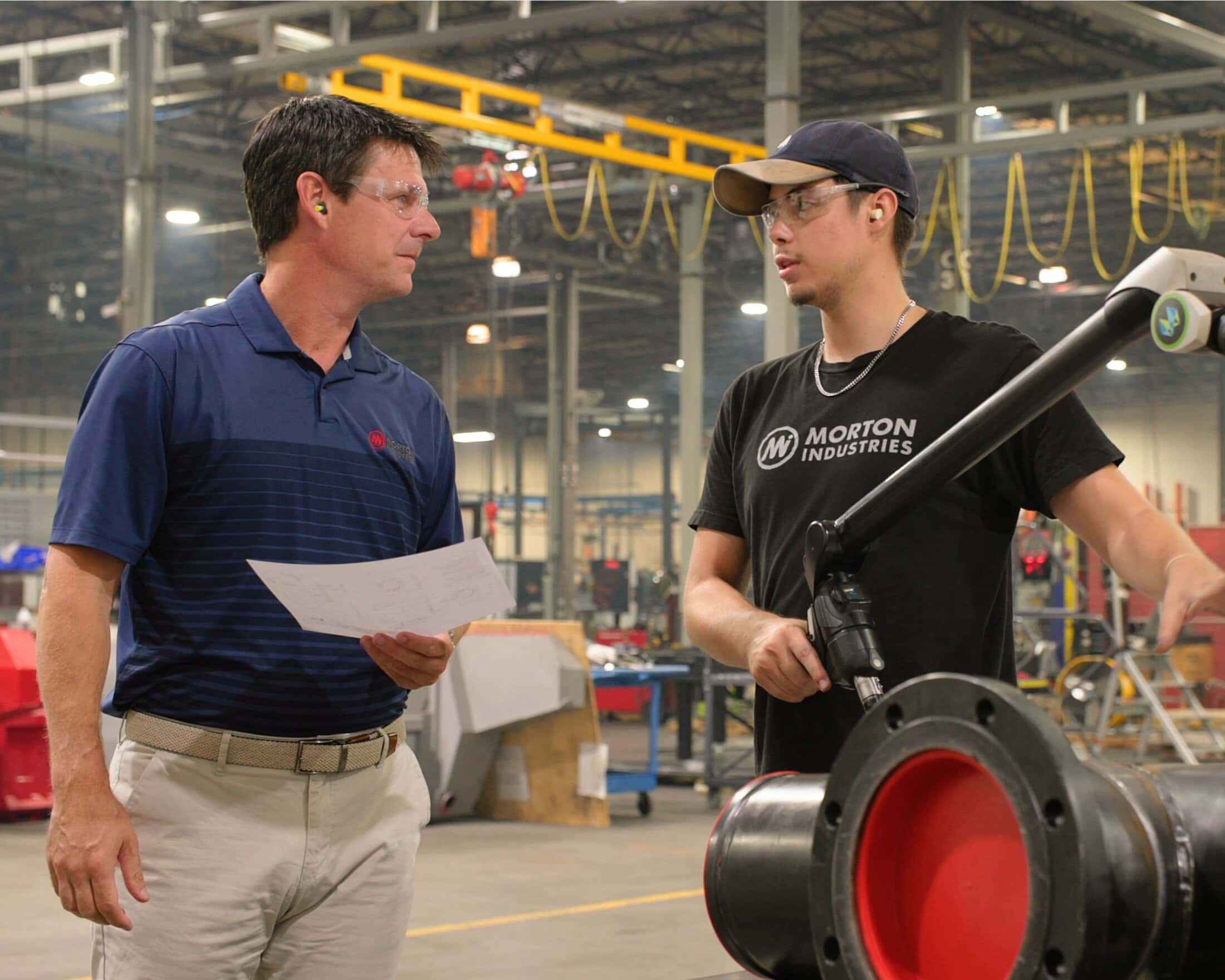 Morton Industries team members reviewing engineering plans and using advanced metrology equipment in a modern manufacturing facility.